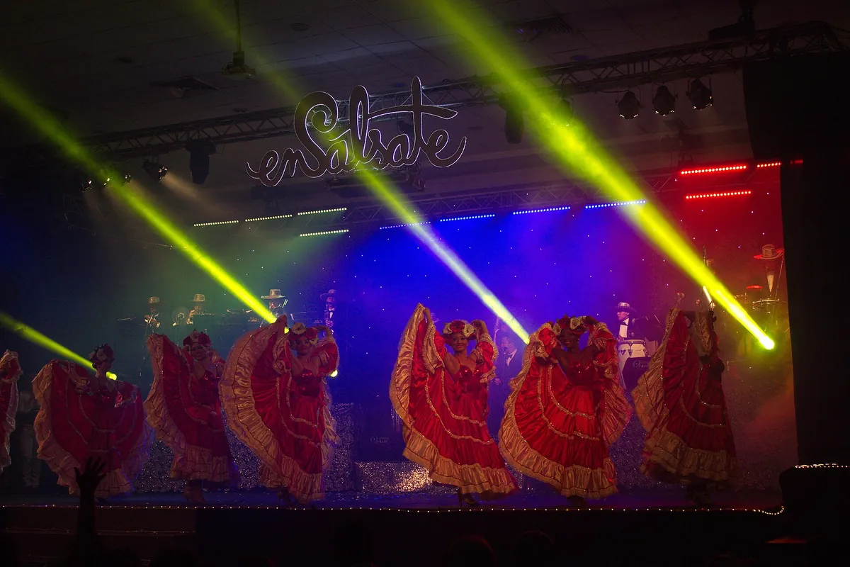 Un espectáculo de salsa en tarima en Cali, con bailarinas de faldas rojas